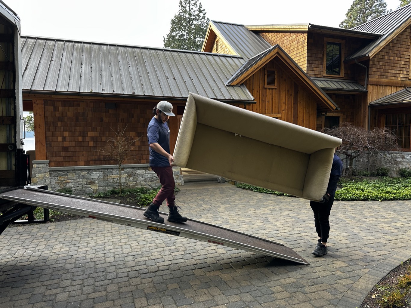 Lake Union Movers crew carrying a sofa down the truck ramp at a Seattle-area home